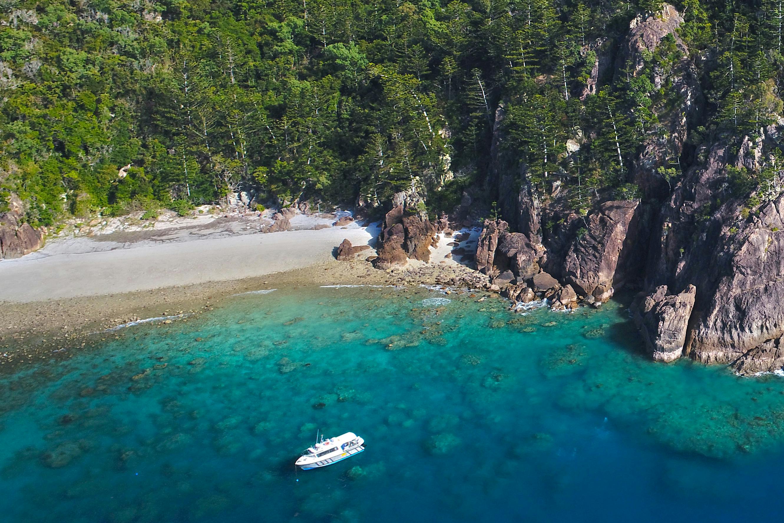 A boat is anchored in secluded cove.
